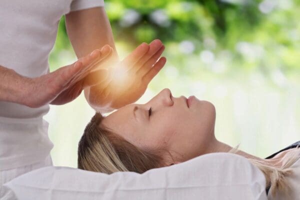 A person is getting reiki treatment from another person.